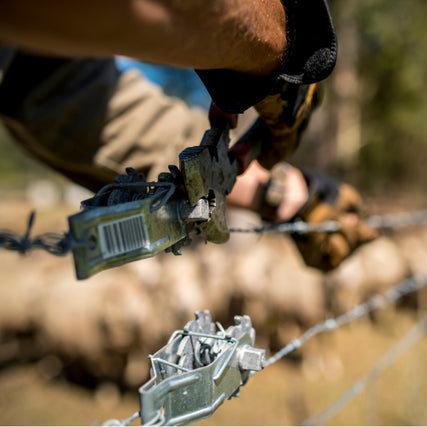 Farm & Ranch SuppliesFarmer putting up a barbed wire fence