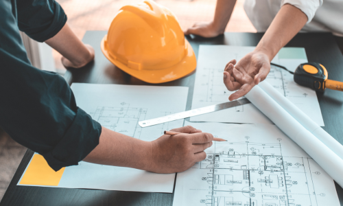 Man writing on blueprint